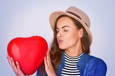 Buy stock photo Woman, kiss face and balloon with heart in studio for romance, love and symbol of gratitude. Eyes closed, pout and female person with inflatable shape by white background for kindness, emoji and care