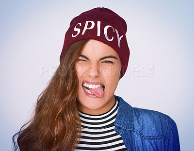 Buy stock photo Portrait, woman and rebel with silly expression in studio for fierce attitude, funky fashion and spicy beanie. Goofy, girl and stick out tongue for rock aesthetic, crazy gesture and purple background