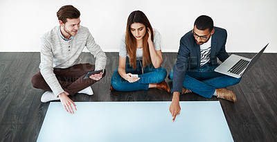 Buy stock photo Studio shot of a group of young people sitting on the floor and working on blank paper