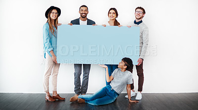 Buy stock photo Studio shot of a group of young people holding a blank placard against a white background