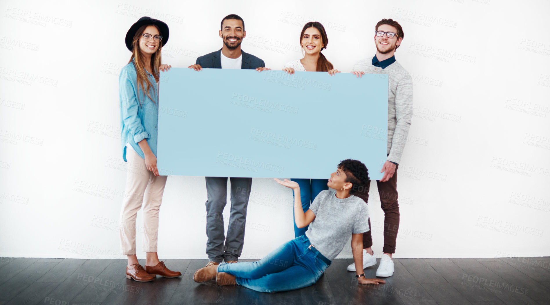 Buy stock photo Studio shot of a group of young people holding a blank placard against a white background