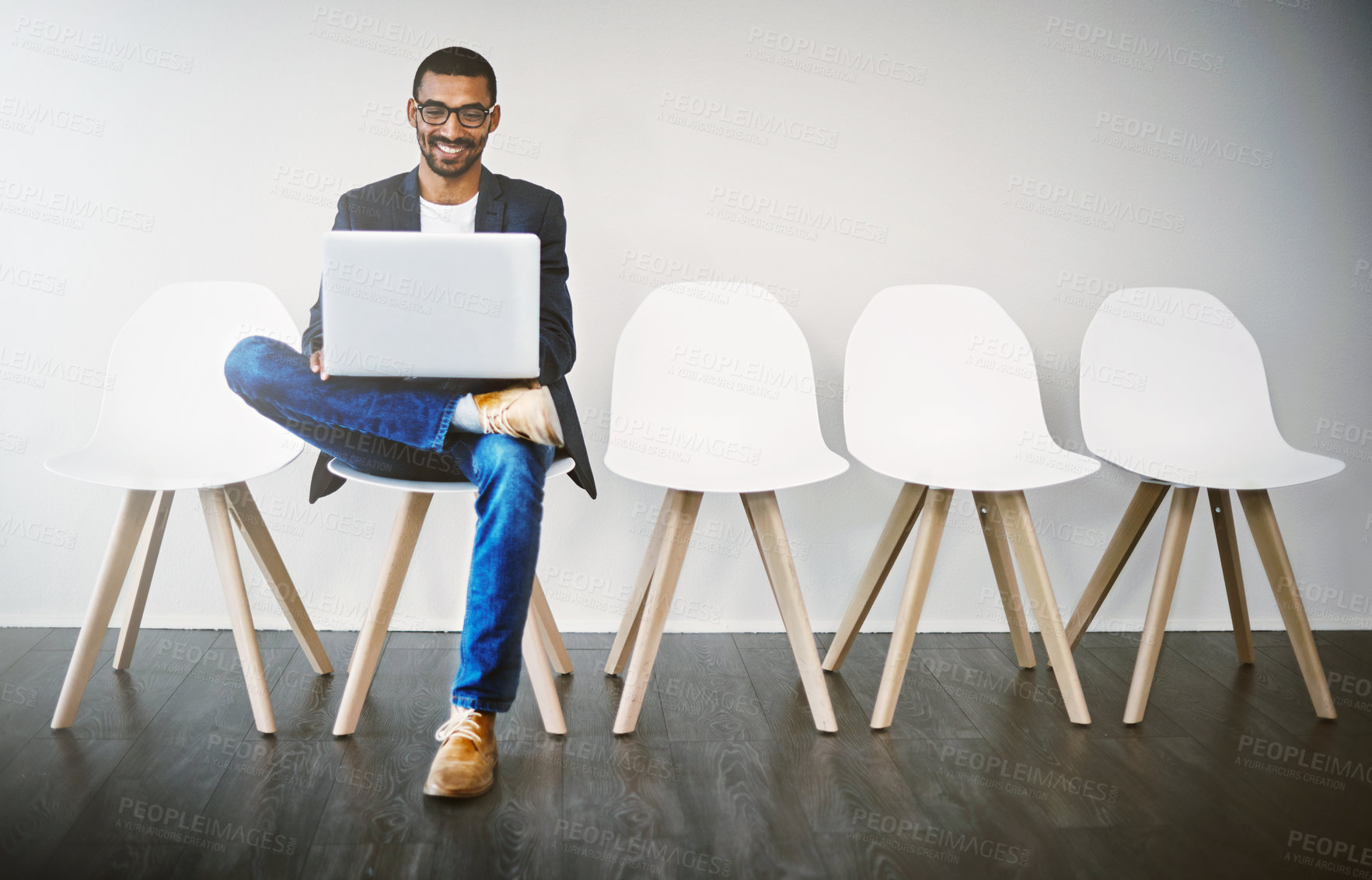 Buy stock photo Shot of a young businessman using a laptop while waiting in line