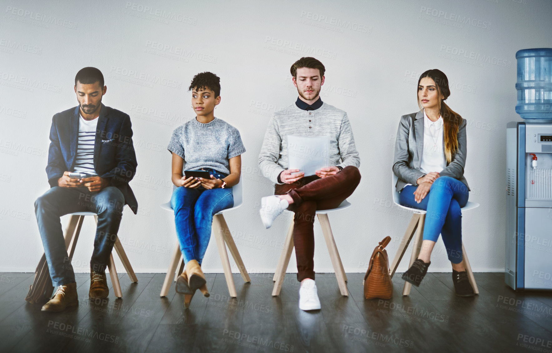 Buy stock photo Shot of a group of young businesspeople waiting in line for a job interview