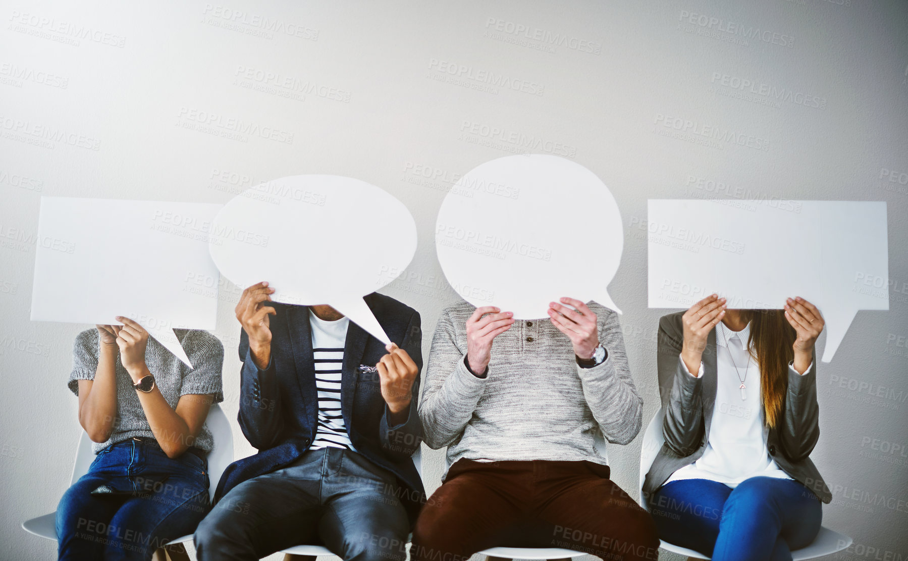 Buy stock photo Shot of a diverse group of businesspeople holding up speech bubbles while they wait in line