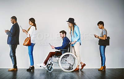 Buy stock photo Shot of a group of businesspeople using wireless technology while waiting in line