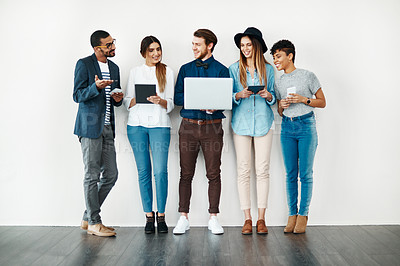 Buy stock photo Shot of a group of young people using wireless technology while standing in line