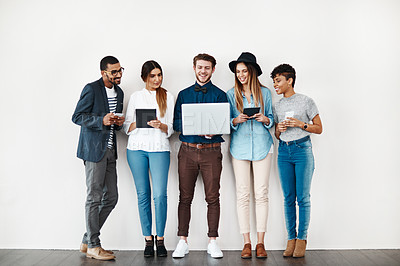 Buy stock photo Shot of a group of young people using wireless technology while standing in line