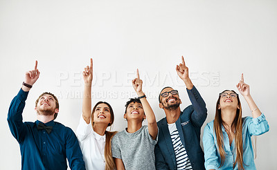 Buy stock photo Shot of a group of young people pointing towards something above them