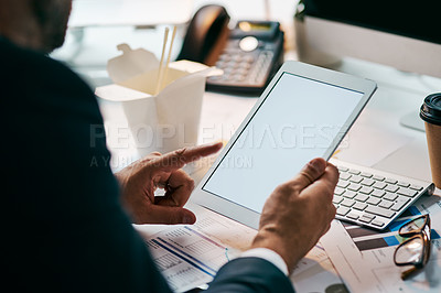 Buy stock photo Shot of an unrecognizable businessman browsing on his digital tablet while being seated in the office during the day