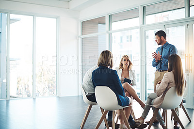 Buy stock photo Cropped shot of a young businessman addressing his colleagues during a meeting in the office