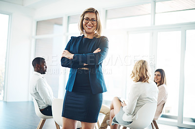 Buy stock photo Cropped portrait of an attractive young businesswoman standing with her arms folded during a meeting in the office