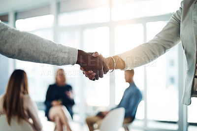 Buy stock photo Cropped shot of two unrecognizable colleagues shaking hands during a meeting in the office