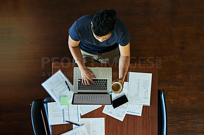 Buy stock photo High angle shot of a young businessman working on a laptop in an office