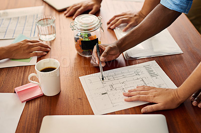 Buy stock photo Closeup shot of an unrecognizable group of businesspeople going through blueprints in an office