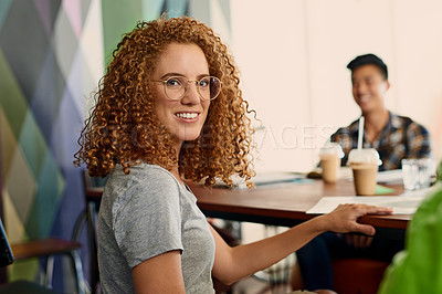 Buy stock photo Portrait of a young designer sitting in an office with her colleagues in the background