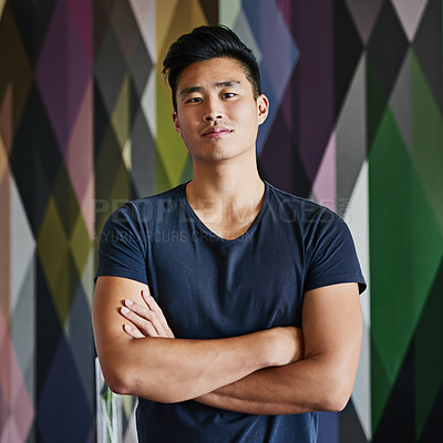 Buy stock photo Portrait of a confident young man standing with his arms folded against a multi colored background