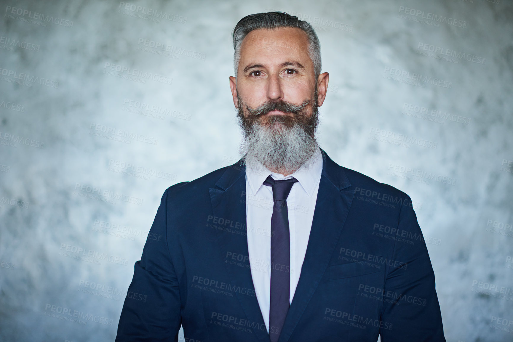 Buy stock photo Portrait of a handsome middle aged businessman wearing a formal suit while standing against a grey background