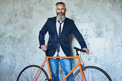 Buy stock photo Studio shot of a confident middle aged businessman holding a red bicycle while standing against a grey background