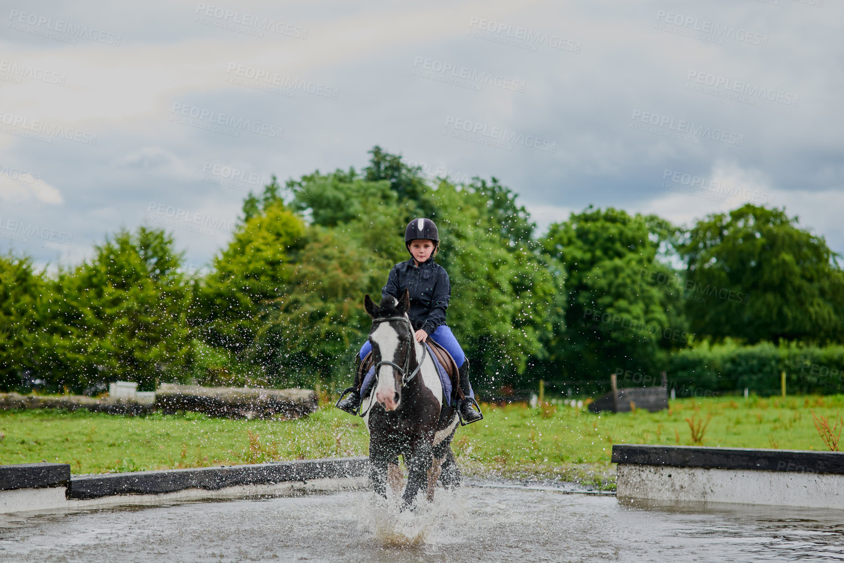 Buy stock photo Shot of a young girl horse riding outdoors