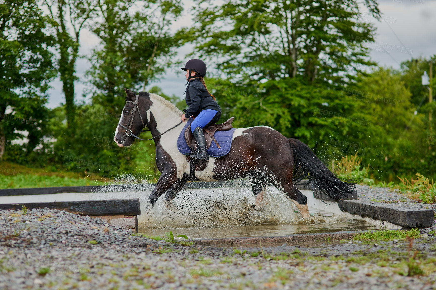 Buy stock photo Shot of a young girl horse riding outdoors