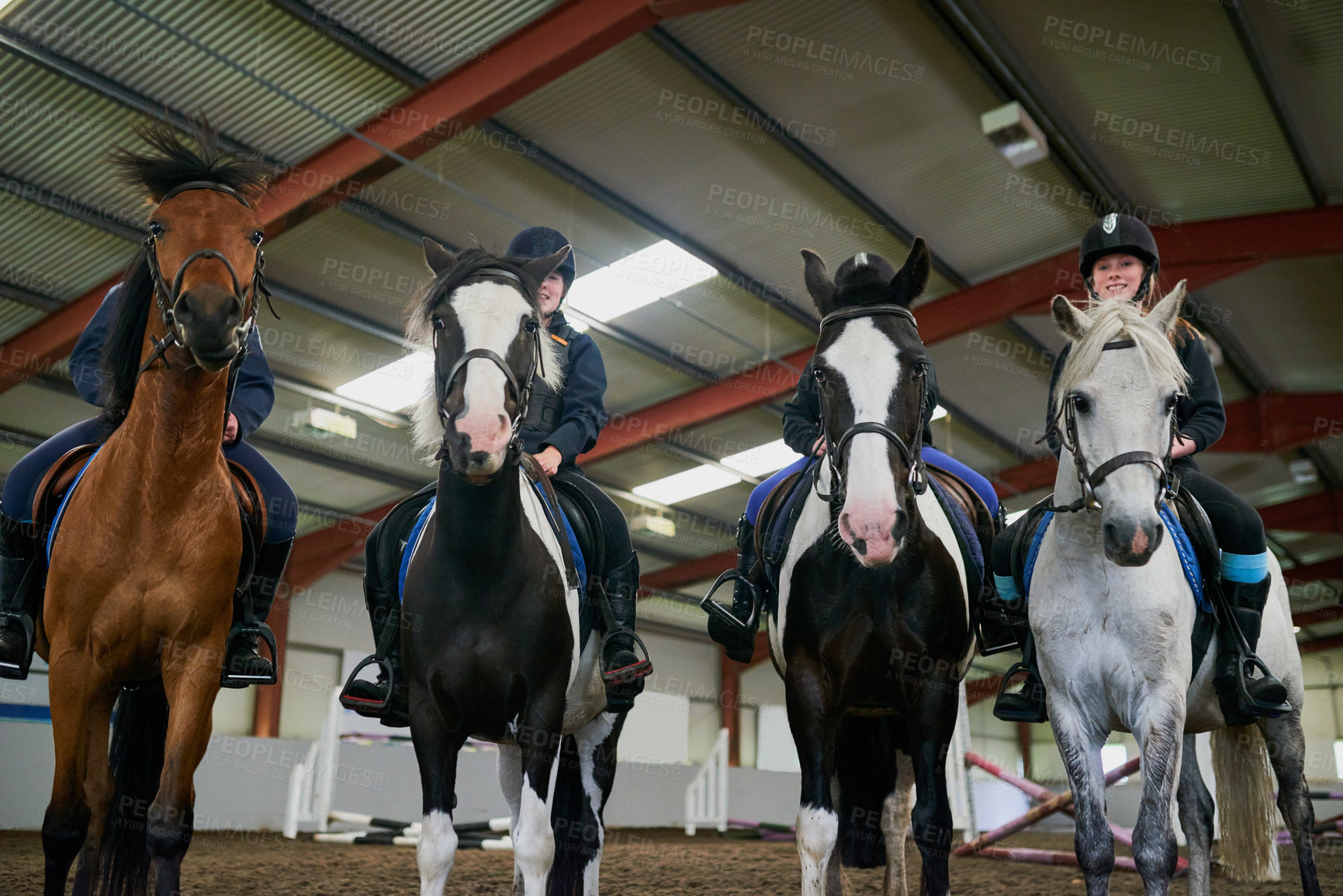 Buy stock photo Low angle shot of young girls sitting on their horses indoors