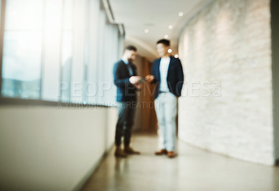 Buy stock photo Blurred shot of two businessmen having a discussion in a modern office
