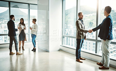 Buy stock photo Shot of group of businesspeople walking around and having casual chats with each other in the office
