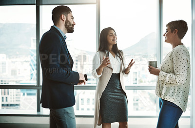 Buy stock photo Shot of group of businesspeople walking around and having casual chats with each other in the office