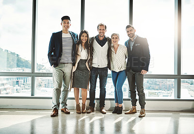 Buy stock photo Portrait of a group of confident businesspeople standing together in the office during the day