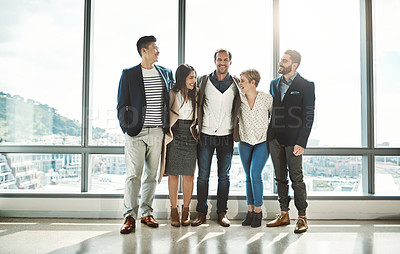 Buy stock photo Portrait of a group of confident businesspeople standing together in the office during the day