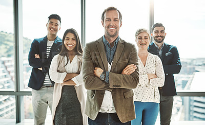 Buy stock photo Portrait of a group of cheerful businesspeople standing together with their arms folded inside of the office