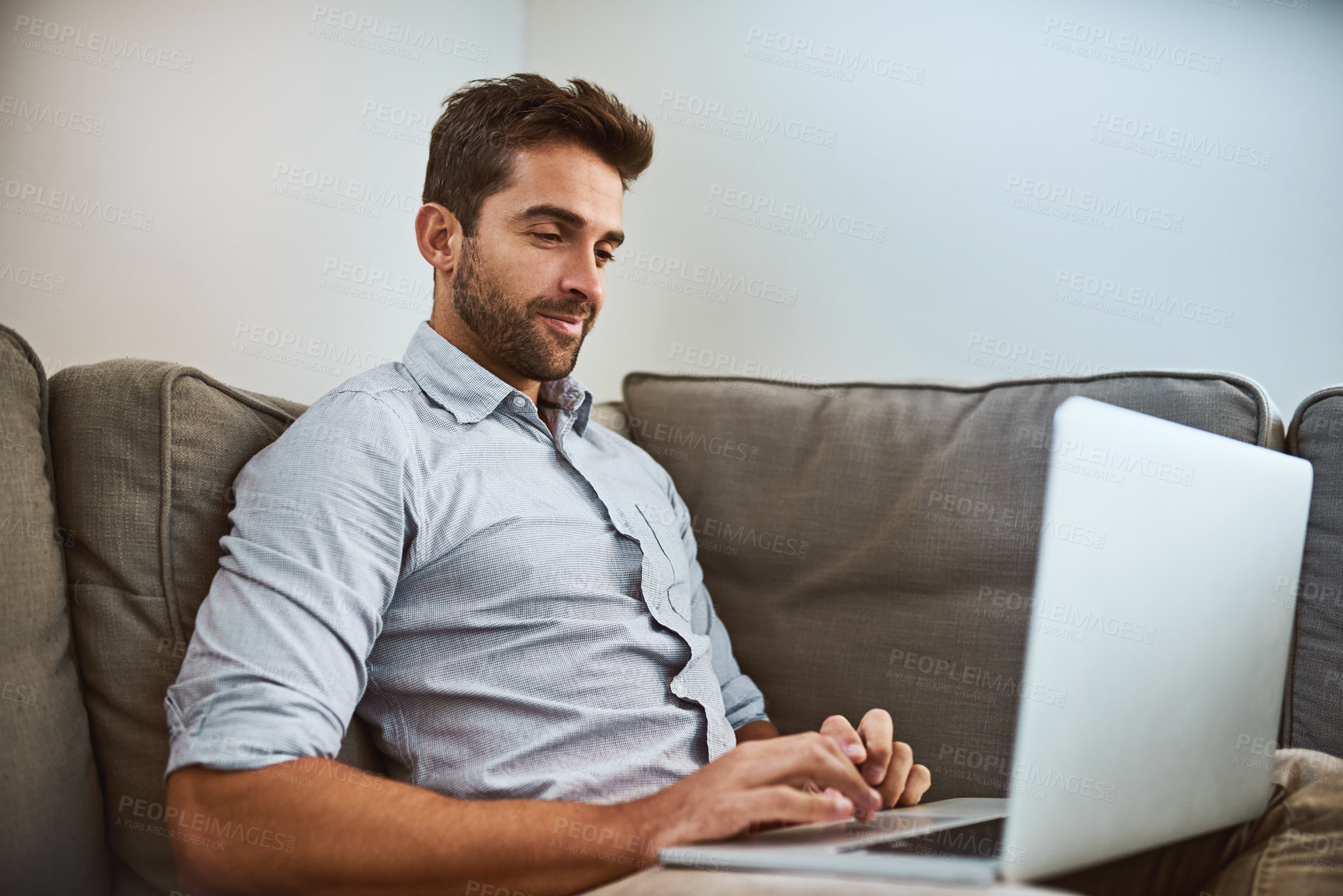 Buy stock photo Man, laptop and typing on sofa for remote work, communication and publishing research in home. Male person, writer and computer for freelance job, copywriting career and connectivity in living room