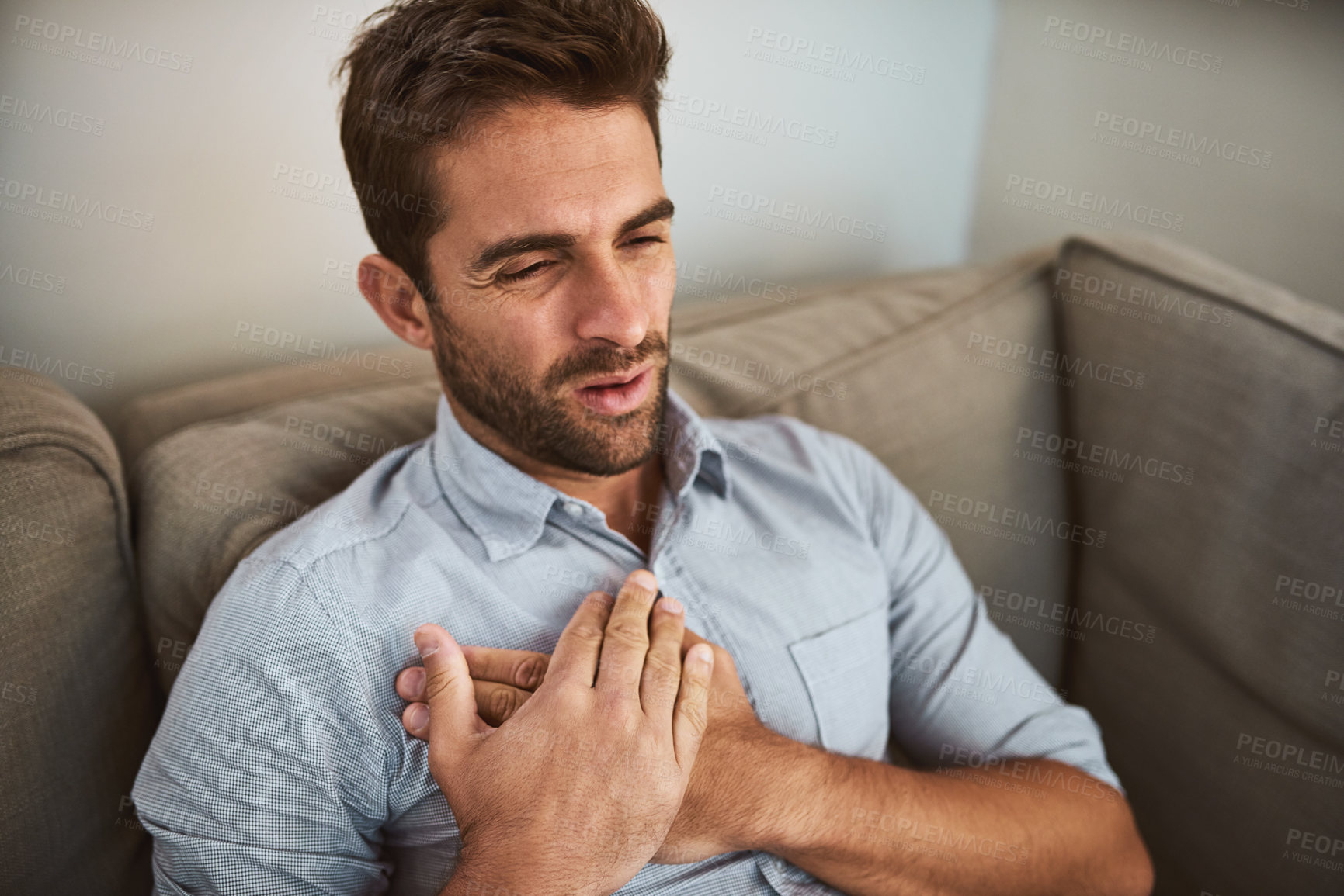 Buy stock photo Man, chest pain and heart attack with stress on sofa for medical emergency, discomfort and cardiac arrest. Professional, person and cardiovascular disease with breathing problem or arrhythmia in home