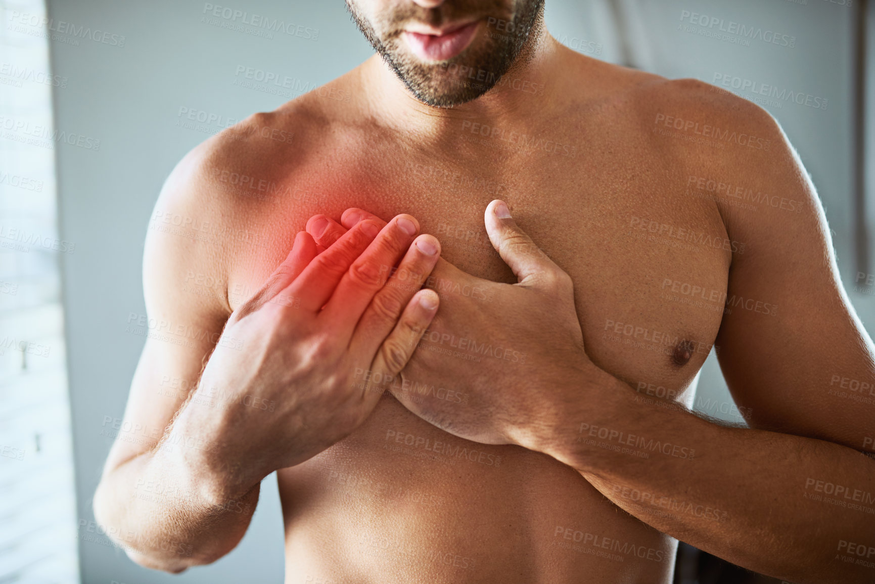 Buy stock photo Shot of a shirtless unrecognizable man holding his chest in discomfort due to pain inside at home
