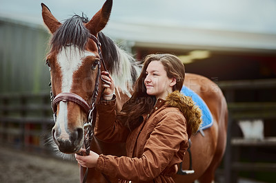 Buy stock photo Shot of a teenage girl standing next to her pony on a farm