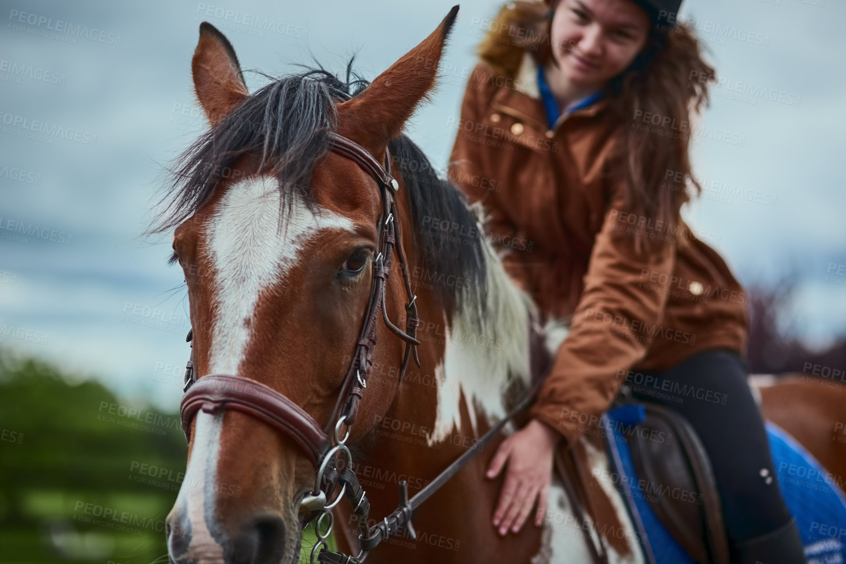 Buy stock photo Shot of a teenage girl riding her pony on a farm