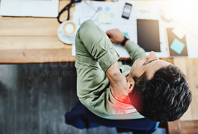 Buy stock photo High angle shot of an uncomfortable young businessman holding his neck in pain while being seated in the office during the day