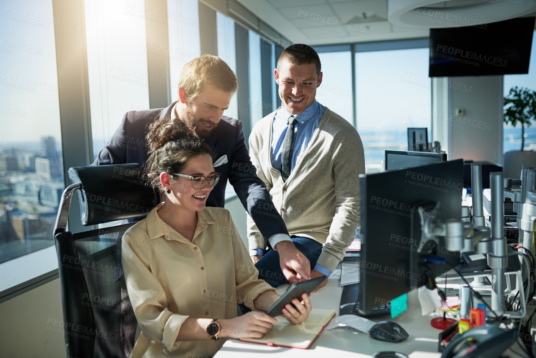 Buy stock photo Shot of a group of young businesspeople working together on a computer inside of the office during the day