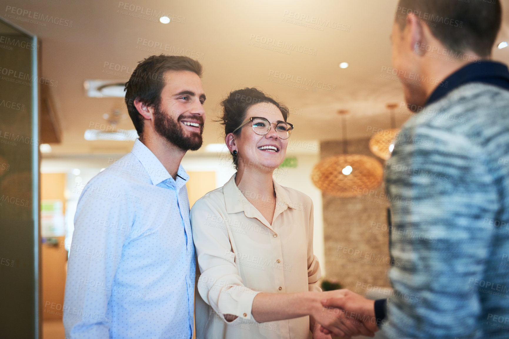 Buy stock photo Shot of two businesspeople shaking hands in an office