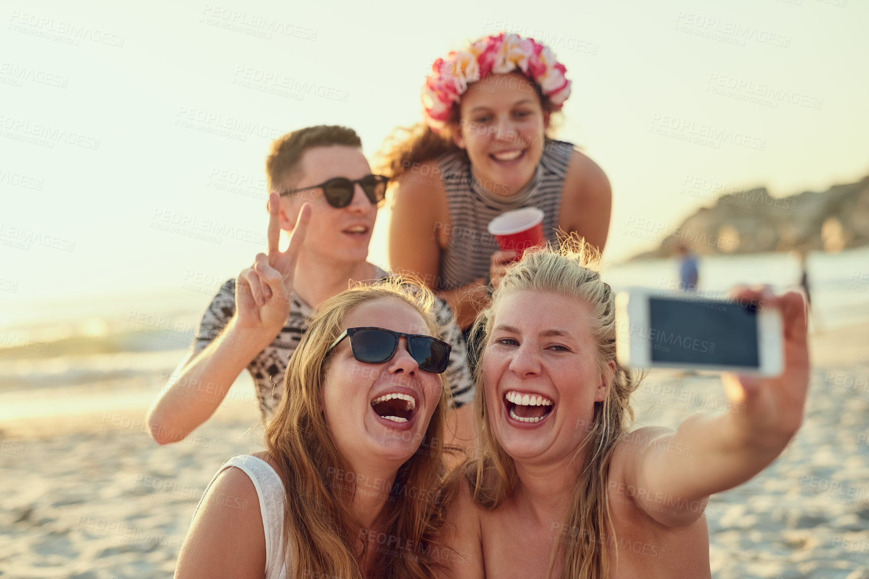 Buy stock photo Shot of young people hanging out at the beach