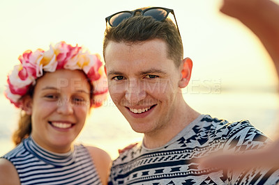 Buy stock photo Shot of a young couple hanging out at the beach