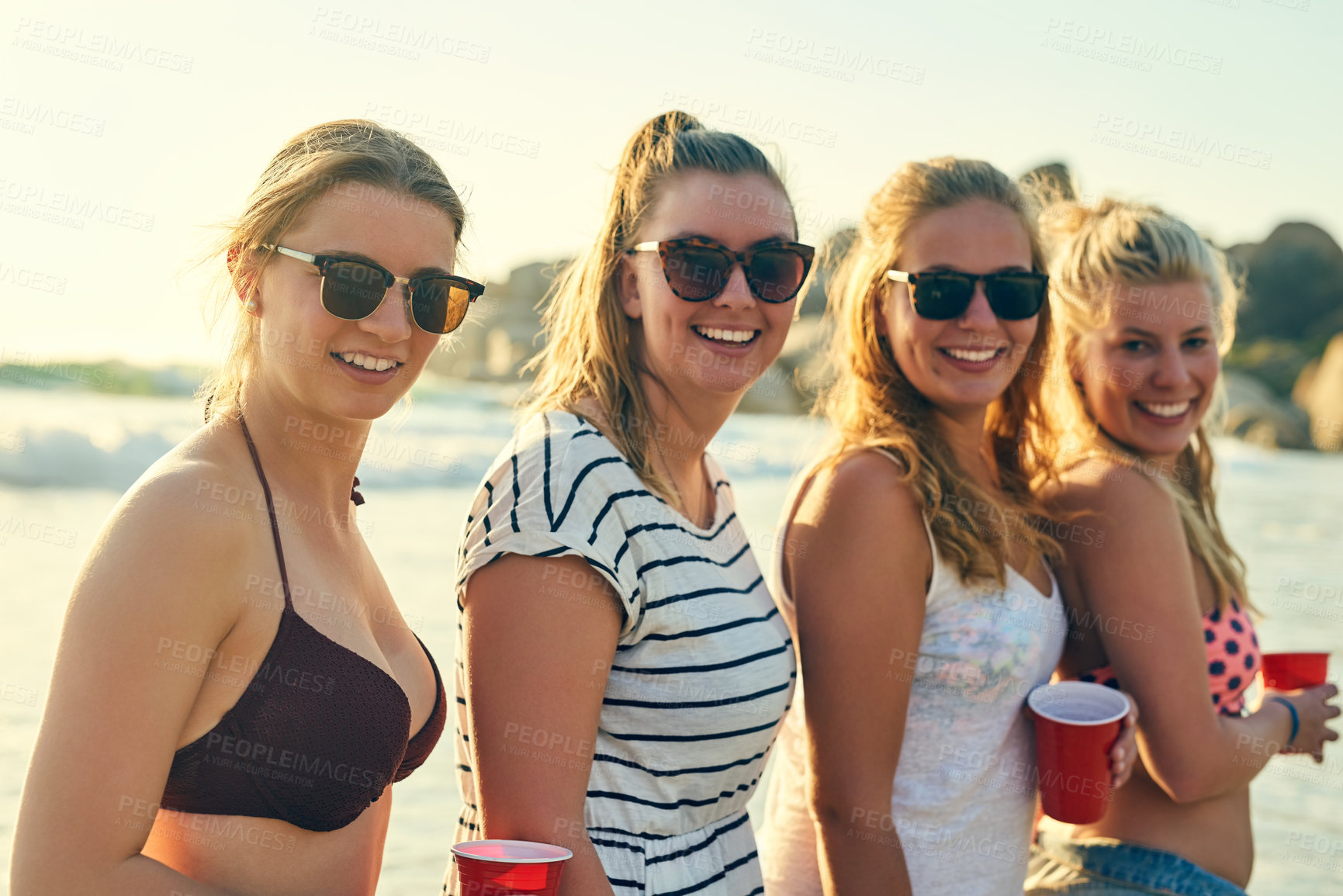 Buy stock photo Shot of young people hanging out at the beach