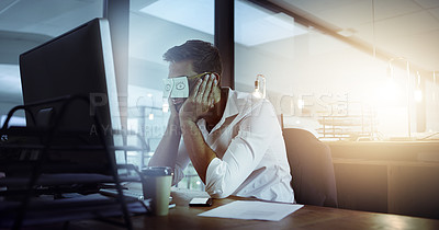 Buy stock photo Cropped shot of a young man with sticky notes over his glasses working late in his office