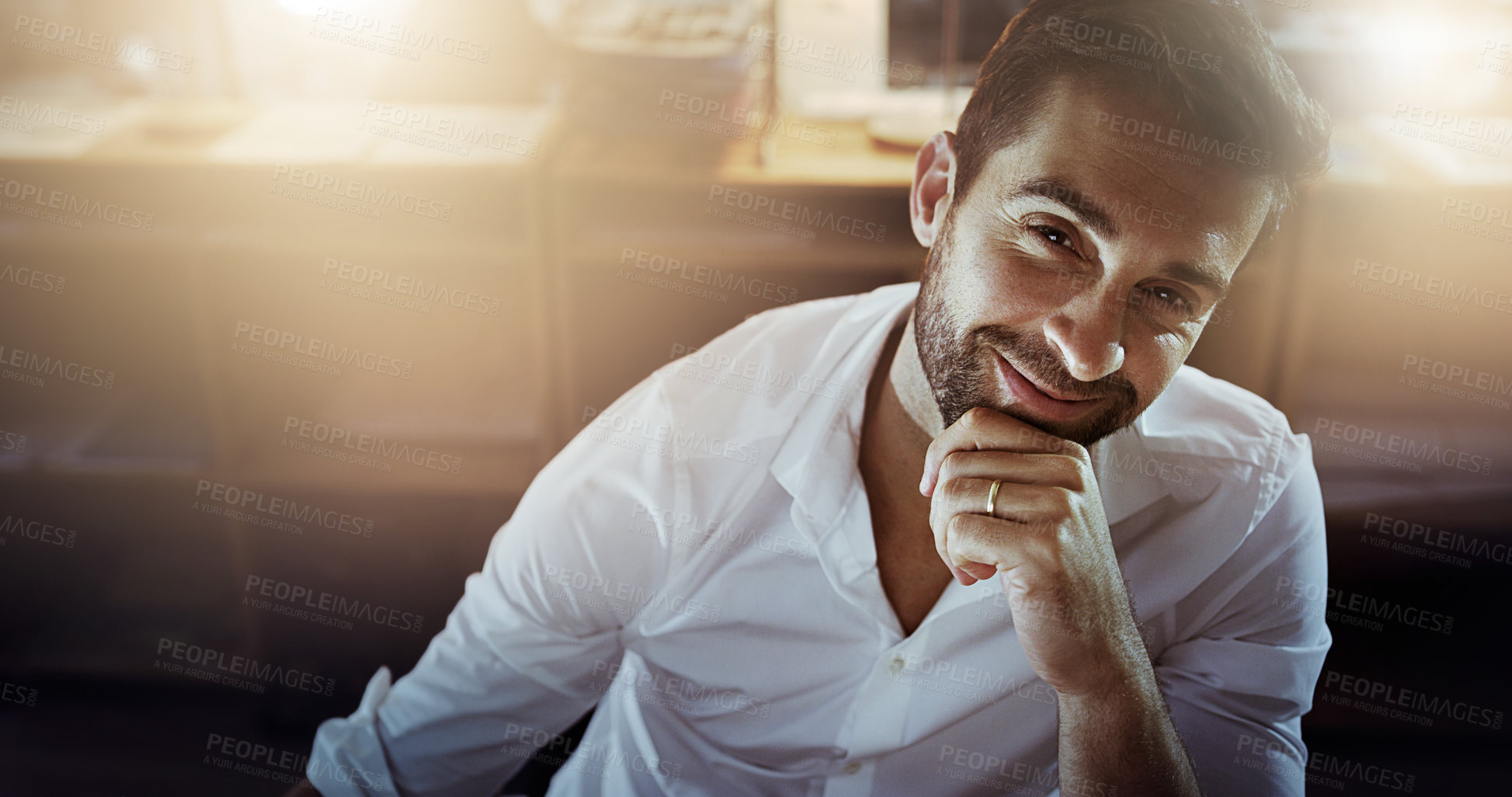 Buy stock photo High angle portrait of a handsome young businessman looking thoughtful while working late in the office