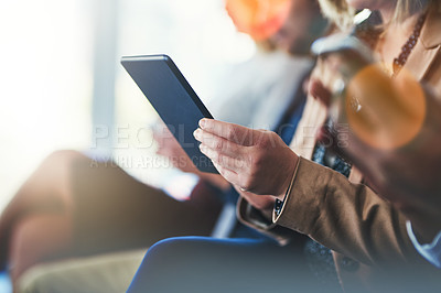 Buy stock photo Cropped shot of a woman using her digital tablet while sitting in a meeting
