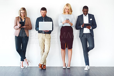 Buy stock photo Shot of a group of entrepreneurs using wireless devices against a white background