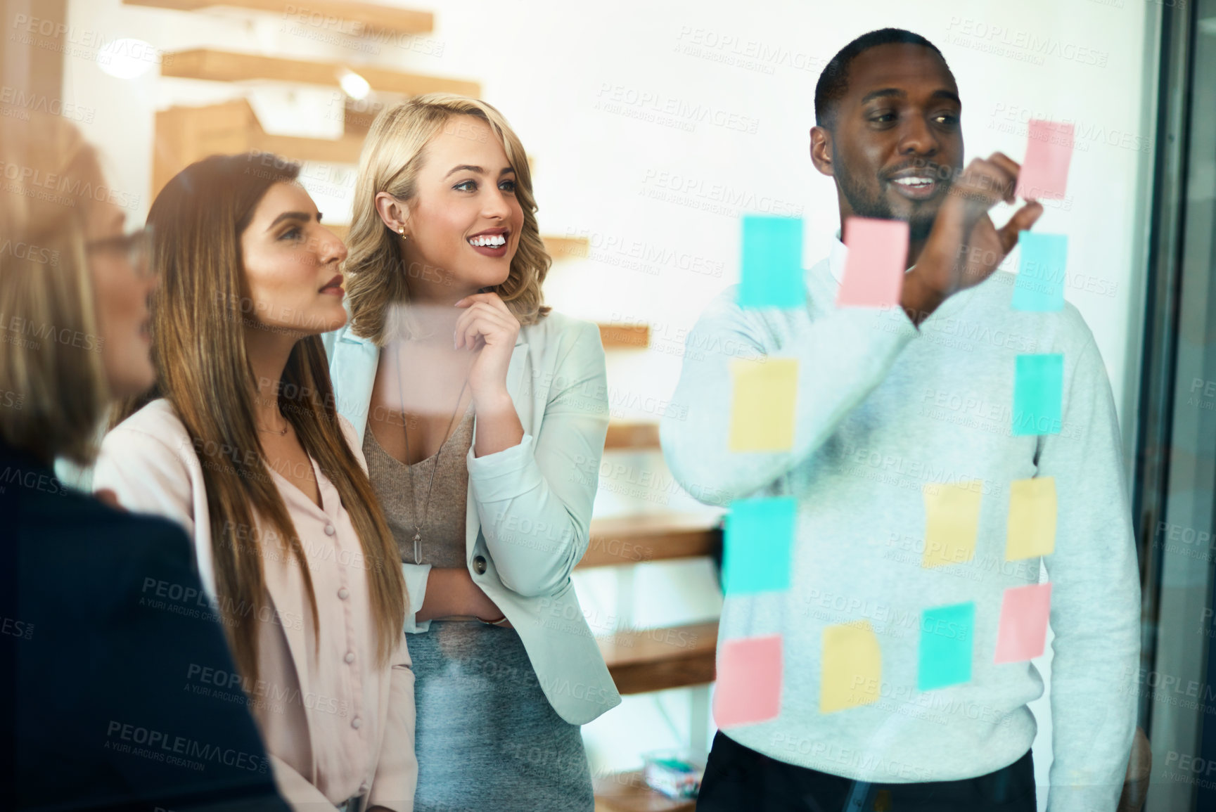 Buy stock photo Business people planning, organizing ideas and strategy with sticky notes while thinking, working together on a marketing project. Busy, innovative and creative young professionals work on a solution