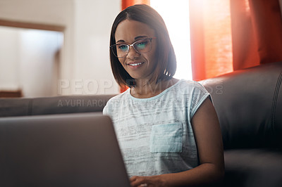 Buy stock photo Cropped shot of an attractive young woman using a laptop at home