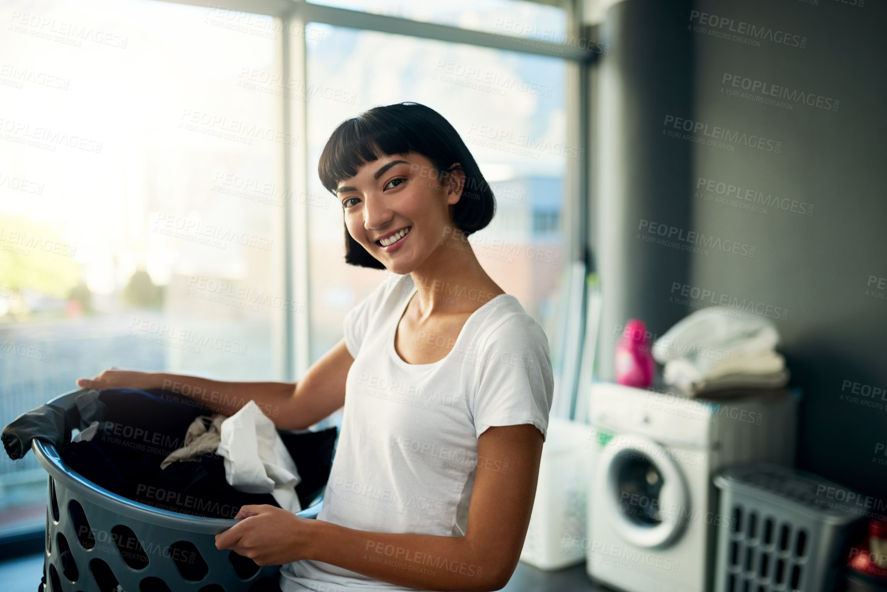 Buy stock photo Cropped shot of a young woman holding a laundry basket