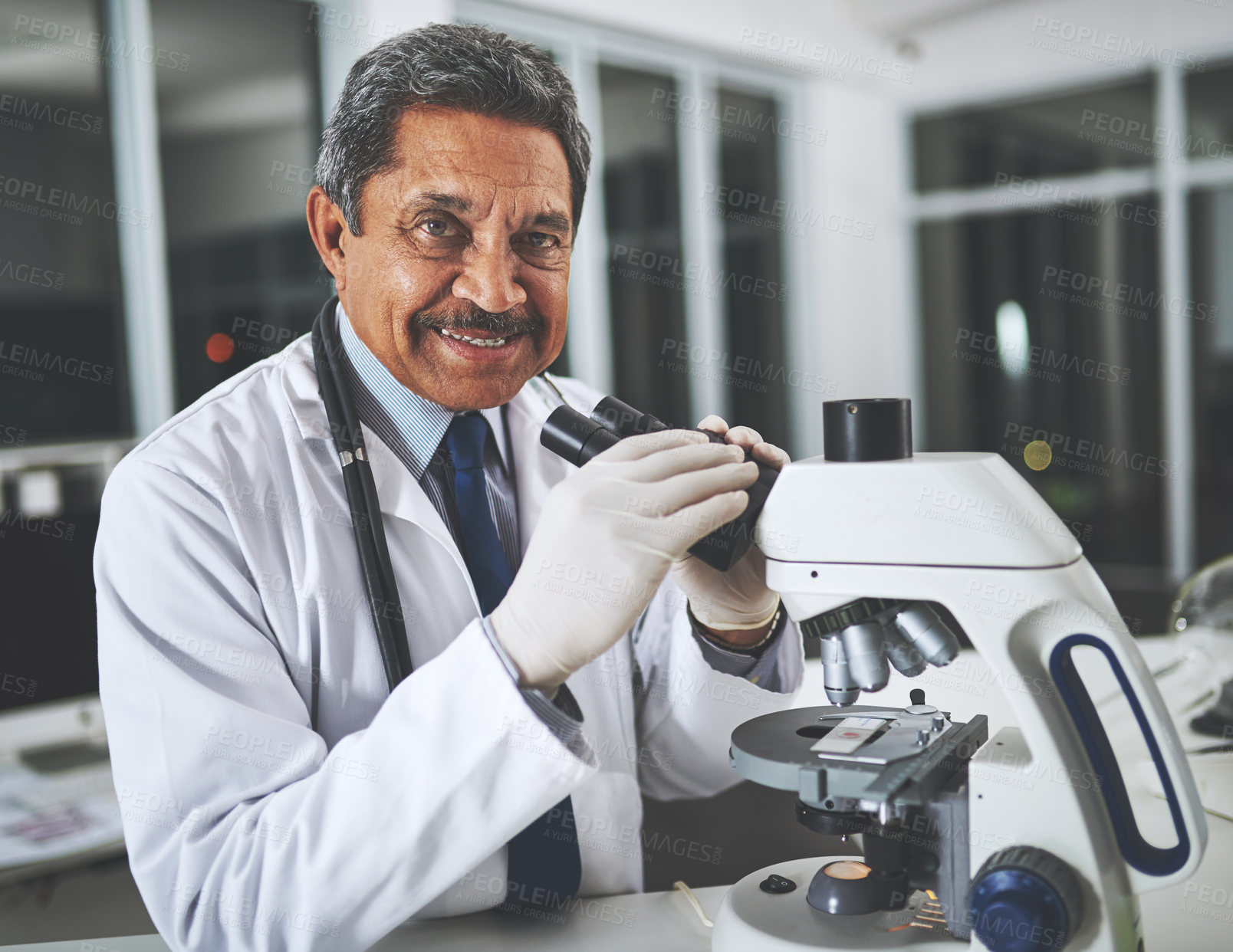 Buy stock photo Shot of a mature scientist using a microscope in a laboratory